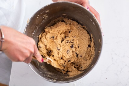 Hand stirring bowl of cookies dough with spatula