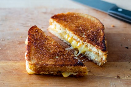 Grilled cheese cut in triangles with melty cheese filling visible 