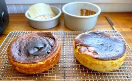 Two Basque-style cheesecakes out of the pans on a cooling rack, pans in the background.
