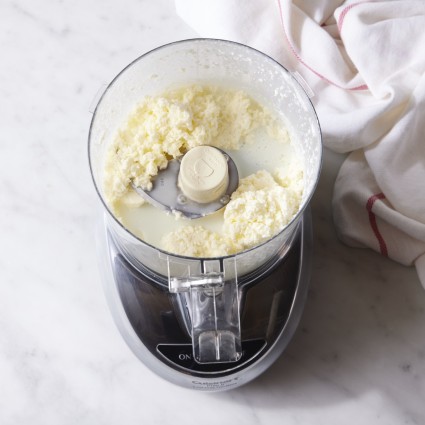 Cream, processed in a food processor, has separated into butter solids and buttermilk.