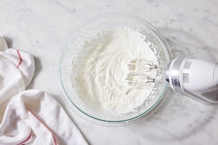 Cream being whipped until fluffy and billowy using an electric hand mixer