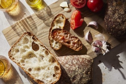 Pan de Cristal on a table with other foods.