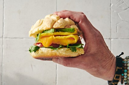 Hand holding a concha breakfast sandwich