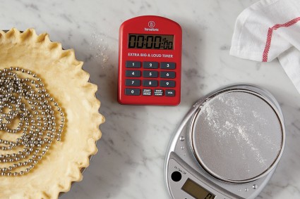 Kitchen timer next to scale and pie crust