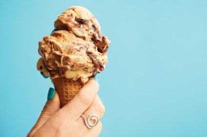 A person holding an ice cream cone with malted milk ice cream