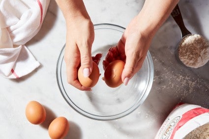 Hands cracking two eggs against each other