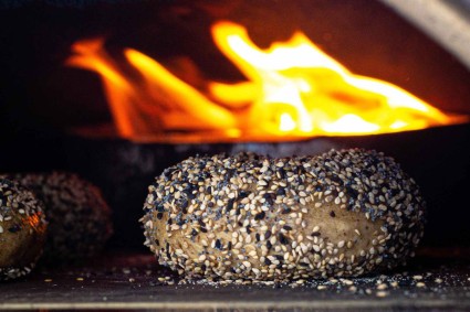 A bagel baking in an Ooni wood-fired oven