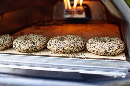 Seeded bagels baking with live fire. 