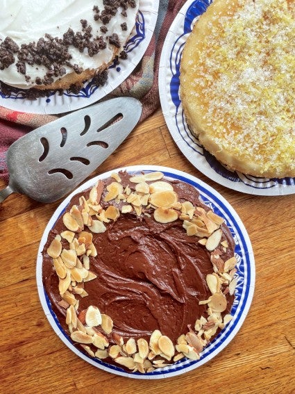 Three 6-inch mini cakes: lemon, chocolate-frosted chocolate, and chocolate with white frosting.