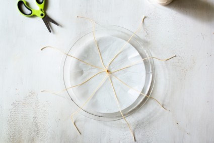 Tied strings in center of parchment-lined pie plate, extended to fall over the rim