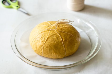 Bread dough, shaped in a ball in pie plate with string tied in the center at the top