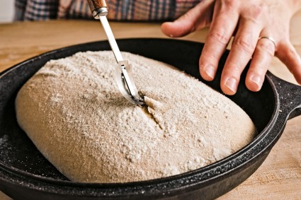 Tara using a lame to cut bread dough