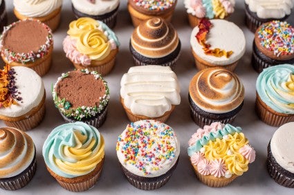 A grid of cupcakes decorated with all different techniques