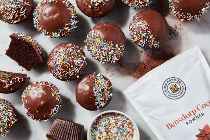 Chocolate cupcakes next to bag of cocoa powder