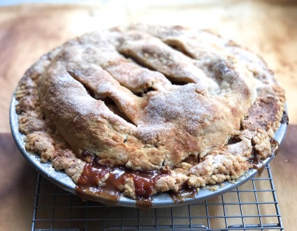 Baked apple pie on a cooling rack.