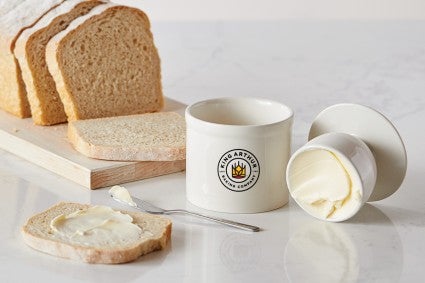 Butter keeper full of butter next to bread