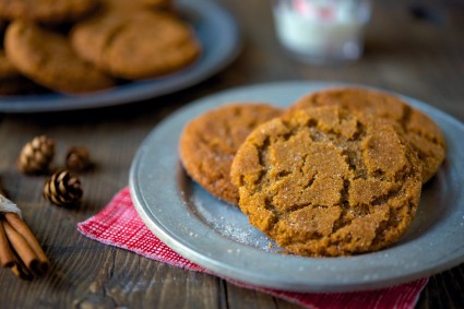 Plate of three gingersnap cookies on a table. 