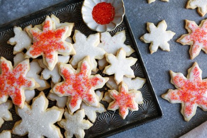 Plate of star-shaped cookies with white frosting on a tray. 