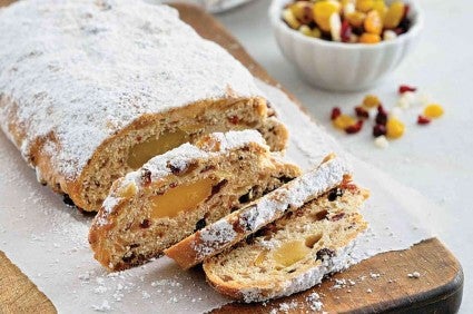 Loaf of stollen sliced on a cutting board. 