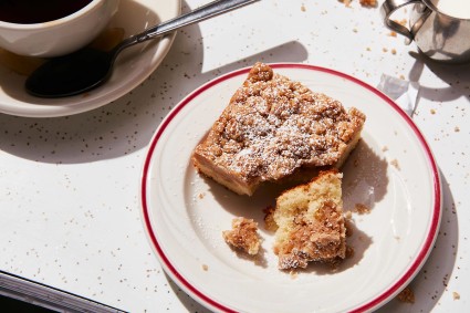 A slice of crumb lover's coffee cake on a plate with lots of crumb toppings