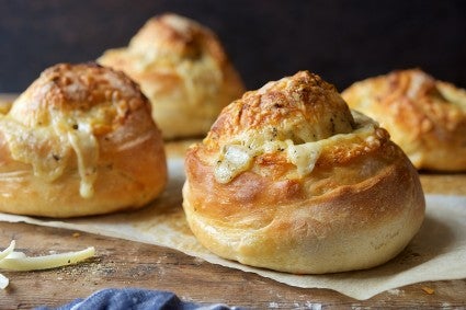 Baked buns with gruyère cheese melted on the sides.