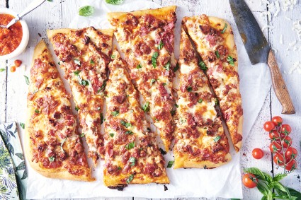 A meat-lover's pizza sliced into long strips