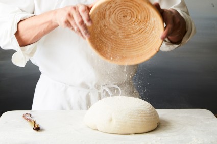 Banneton being used to flip bread dough out