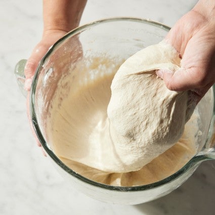 A wet dough being folded