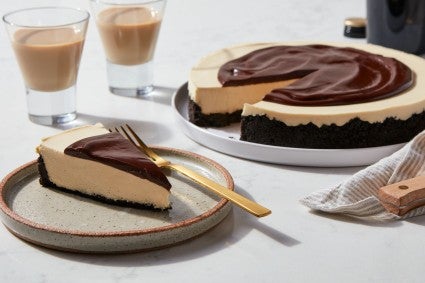 Slice of cake on plate with full cake in background.