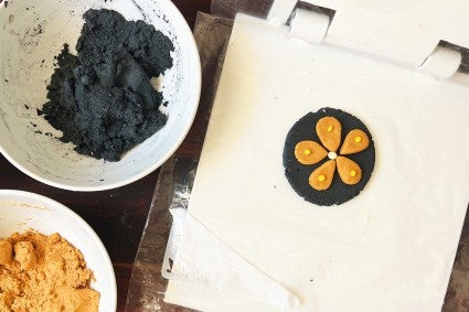 Tortilla in tortilla press with orange flower design