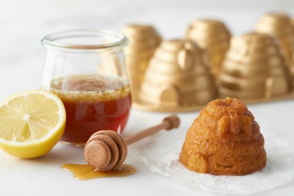 A jar of honey, half a lemon, and a small beehive-shaped honey cake