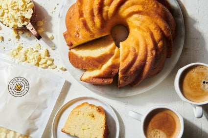 A lemon Bundt cake next to a bag of lemon crumbles