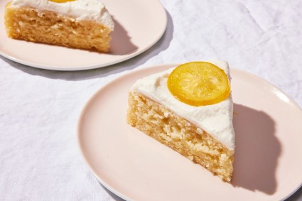 A slice of a simple lemon cake, frosted and topped with a candied lemon slice