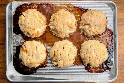 Mini pies in which the filling has leaked and baked onto the muffin pan they're in