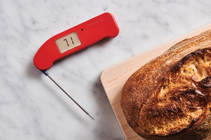 Digital thermometer next to loaf of bread