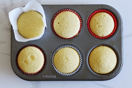 A six-cup muffin pan with different liners in each well, each with a baked cupcake