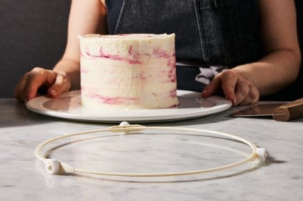 Microwave ring on baking counter, with layer cake on round plate in the background