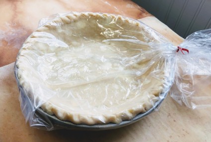 Pie crust in a pan, all wrapped in a plastic bag prior to refrigeration.
