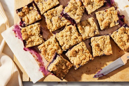 Sliced bars on a cutting board showing jammy blueberry filling.