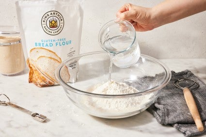 Baker mixing bread dough with gluten-free bread flour