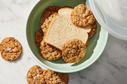 Slice of white bread in storage container full of cookies