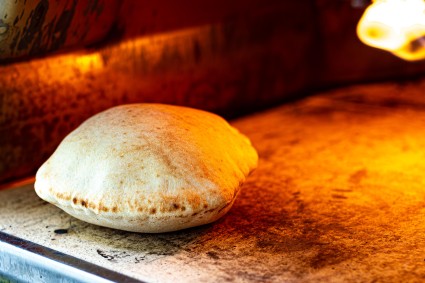 Golden pita baking in an Ooni pizza oven