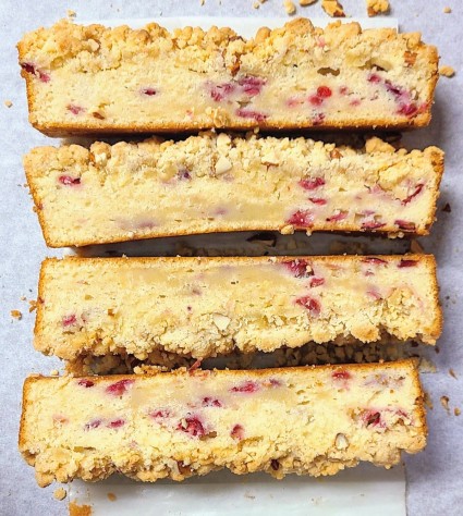 Flat slices of cranberry-almond coffee cake showing compressed (unrisen) batter on the bottom.