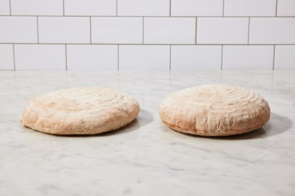 Two baked loaves of bread next to each other, one noticeably taller