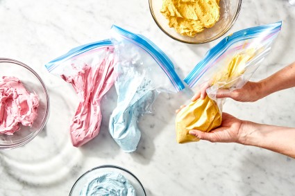 Yellow, pink, and blue icings in ziploc bags