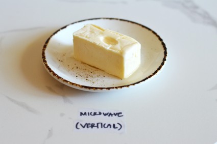 Stick of softened butter with indent left by a finger