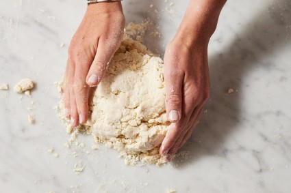 Baker shaping pie dough into a disk
