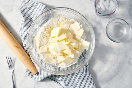 Sliced butter in a bowl of flour to make pie dough