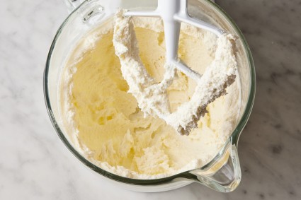 Over-creamed butter and sugar in stand mixer bowl with paddle attachment