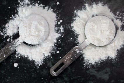 Bleached cake flour in a measuring cup next to unbleached cake flour in a measuring cup